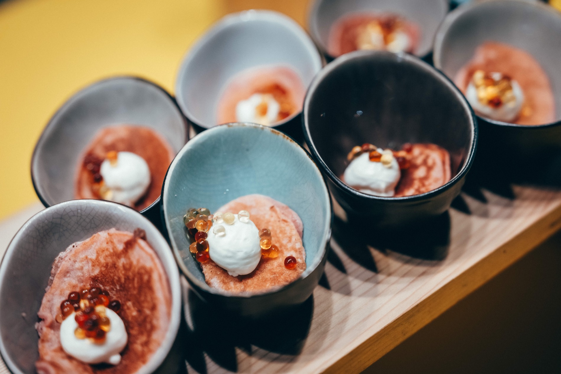 Angerichtete Bowls: Tatar, Ei und frische Kräuter in Keramikschalen